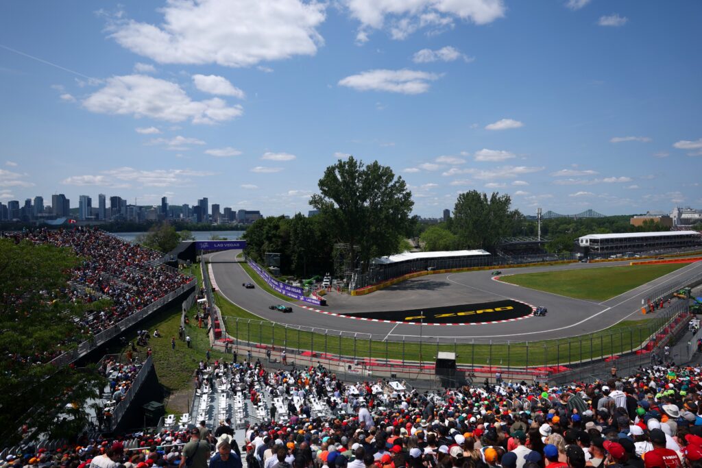Formula 1 race track with spectators and city skyline.