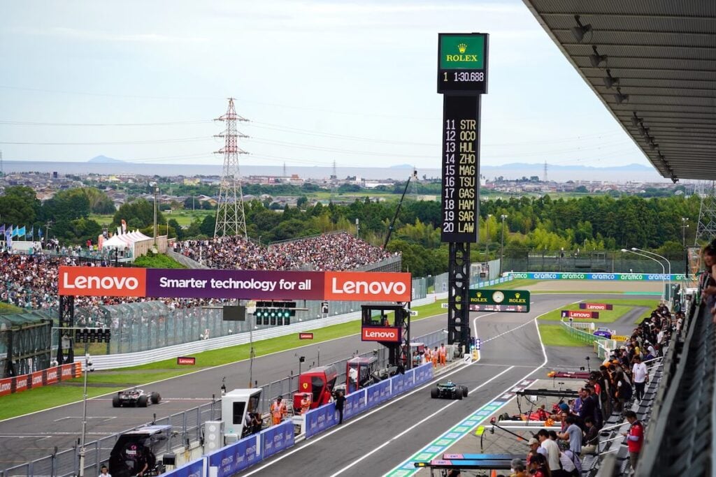Formula 1 race track with standings board and crowd.