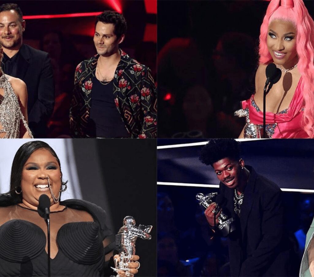 Celebrities holding awards at music event.