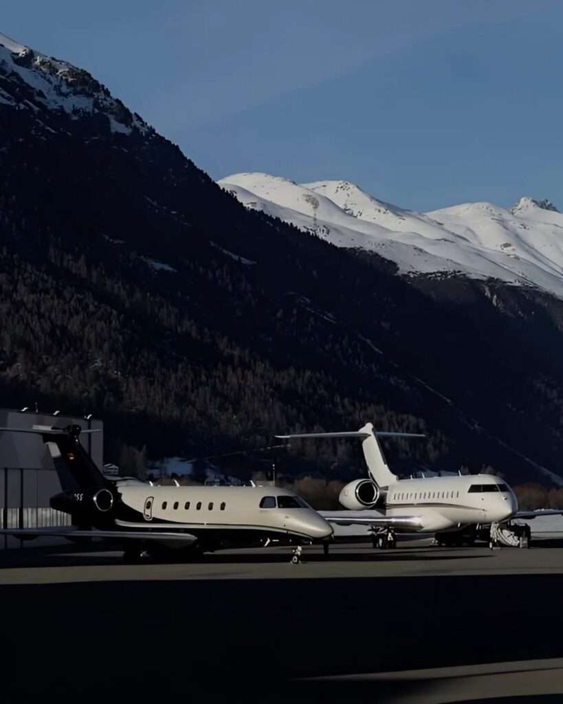 Private jets parked near snowy mountains