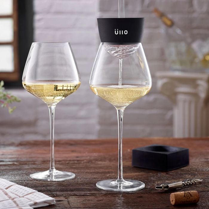 Wine aerator filtering white wine into glasses.