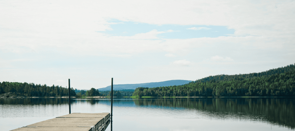 Tranquil lake with dock and forested hills
