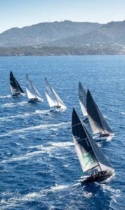 Sailboats racing in ocean near mountains