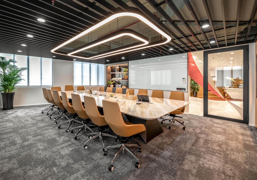 Modern conference room with long table and chairs.
