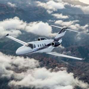 Private jet flying above clouds and mountains.