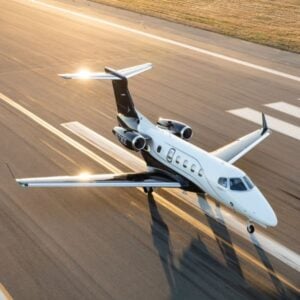 Private jet landing on runway at sunset.