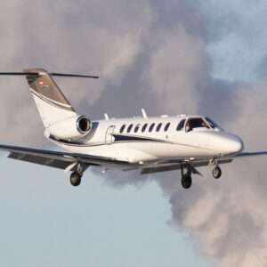 Private jet flying in cloudy sky