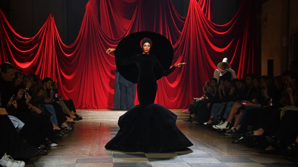 Model in dramatic black gown on runway