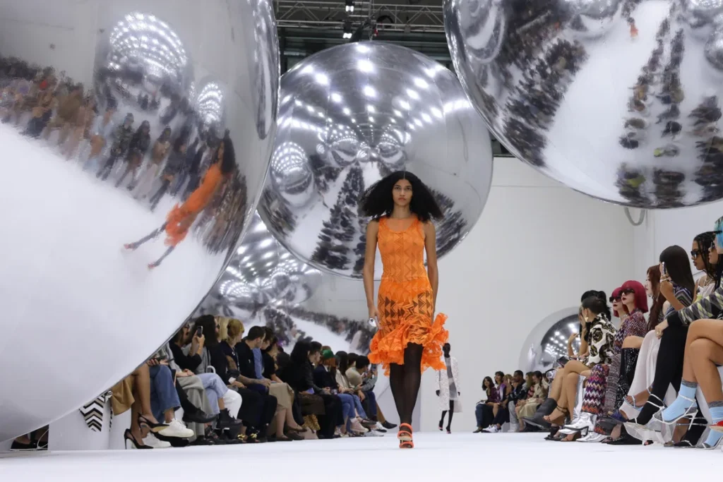 Model in orange dress on futuristic runway