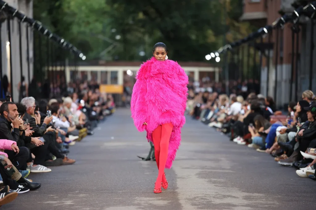 Model in bright pink fur outfit on runway
