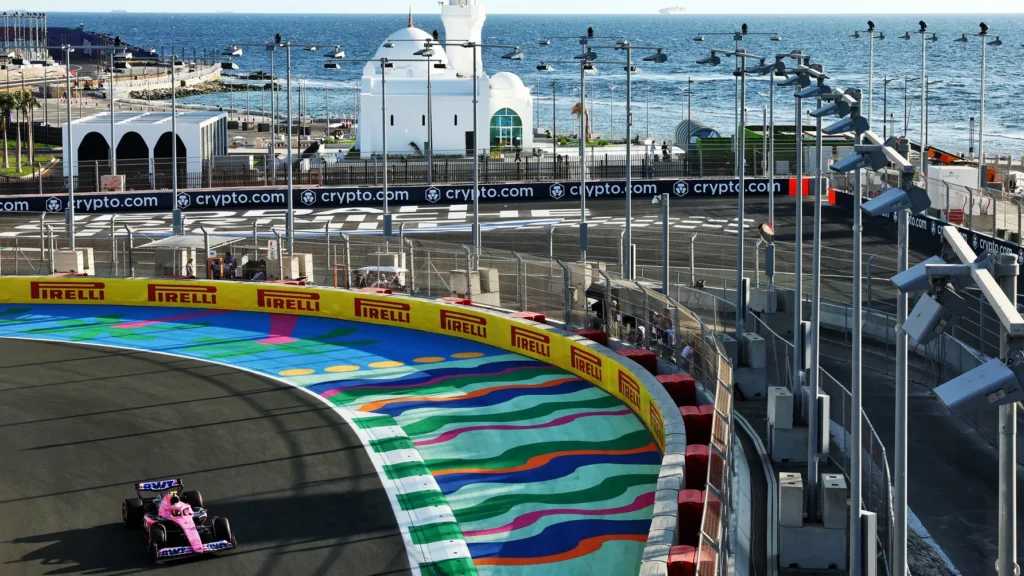 Racing car on colorful track by sea and mosque.