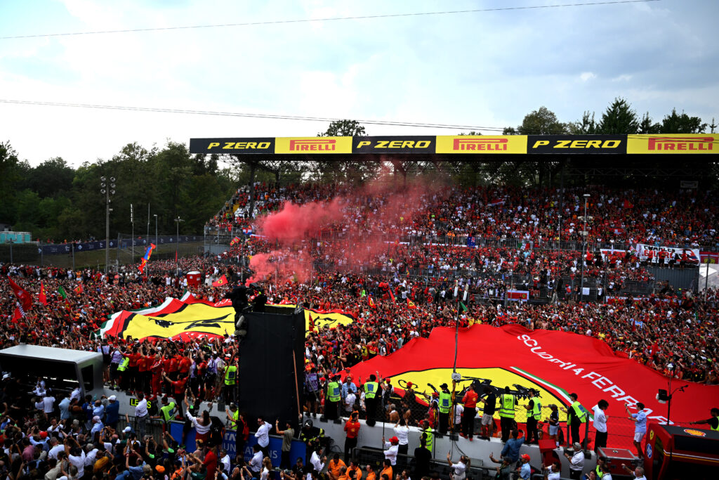 Crowd at a race event with large Ferrari flag.