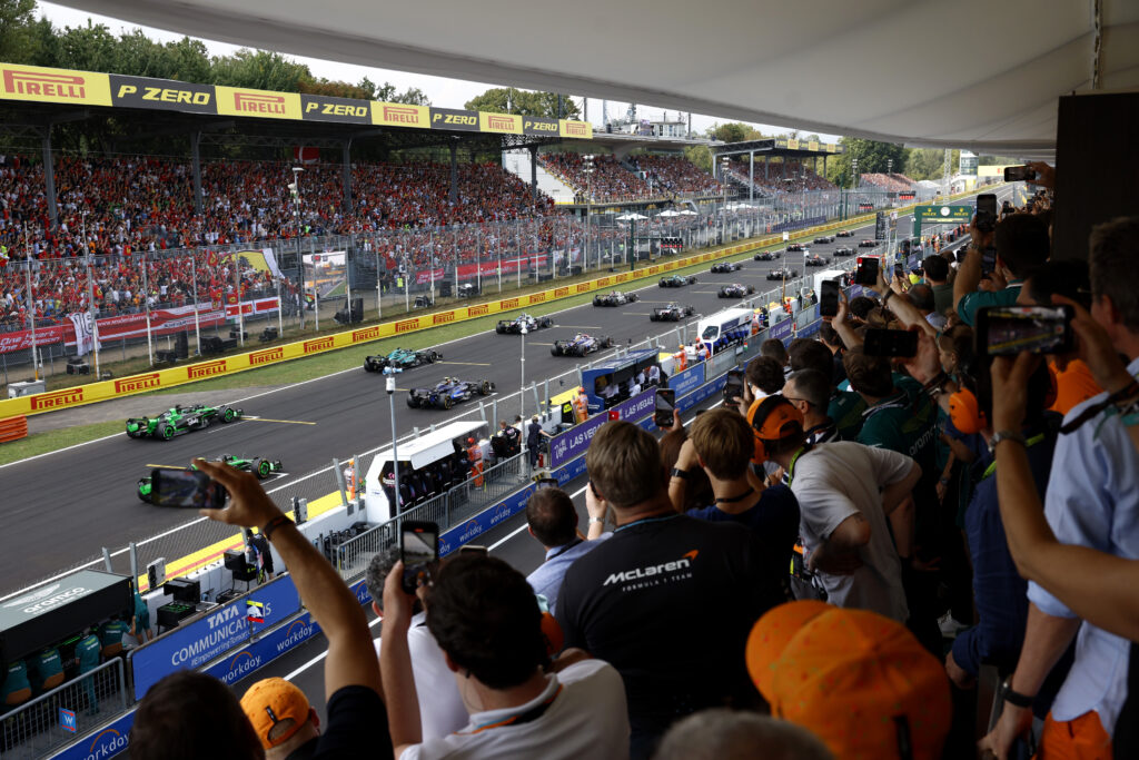Crowd watches cars at a Formula 1 race.