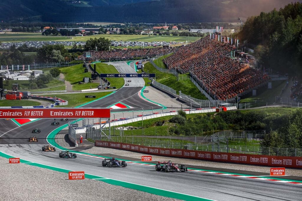 Formula 1 race with spectators in stadium.