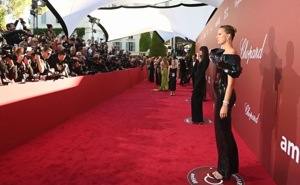 Celebrities pose on red carpet at gala event.