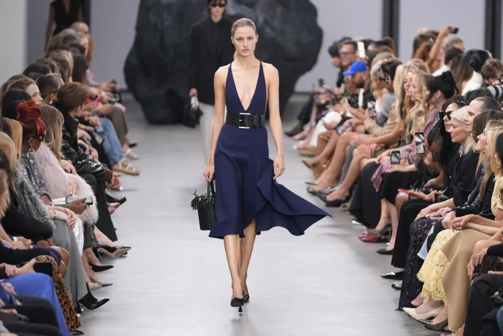 Model in deep blue dress on runway