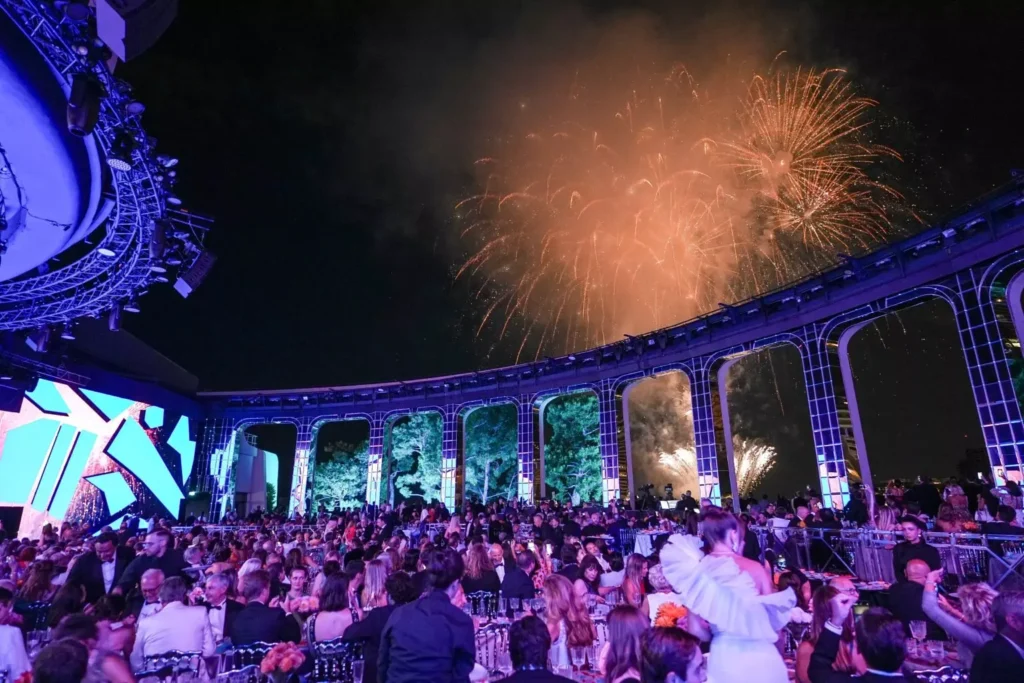 Crowded event with fireworks and colorful lighting display.
