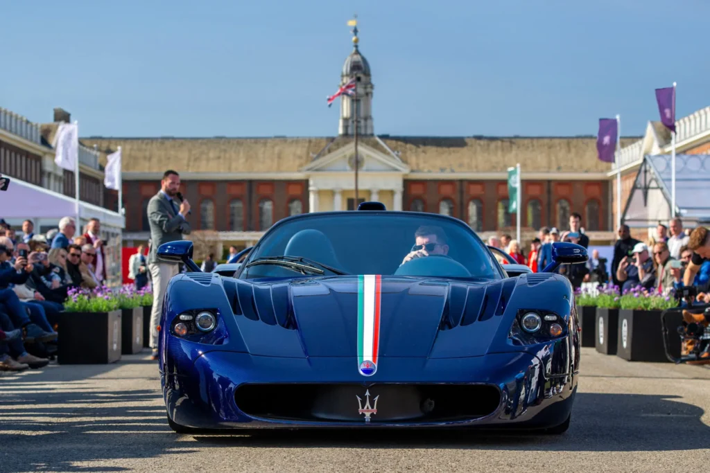 Blue Maserati sports car at event with audience.