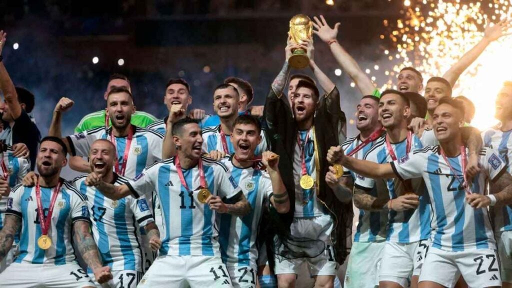 Soccer team celebrating World Cup victory with trophy.