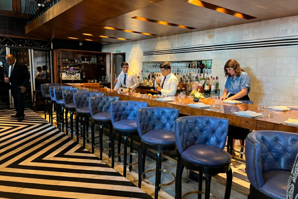 Upscale bar with blue stools and bartenders