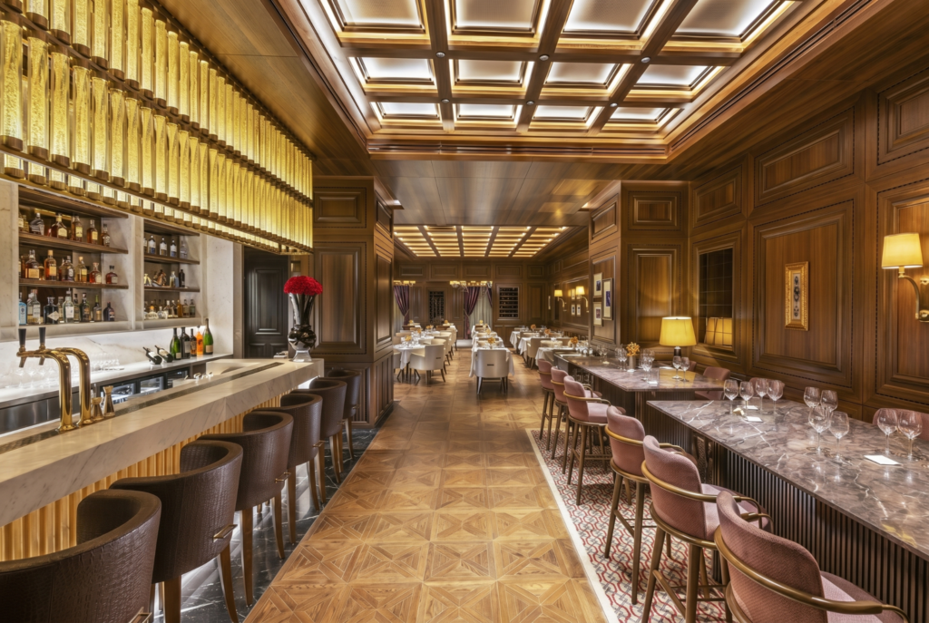 Elegant wood-paneled restaurant with marble bar and tables