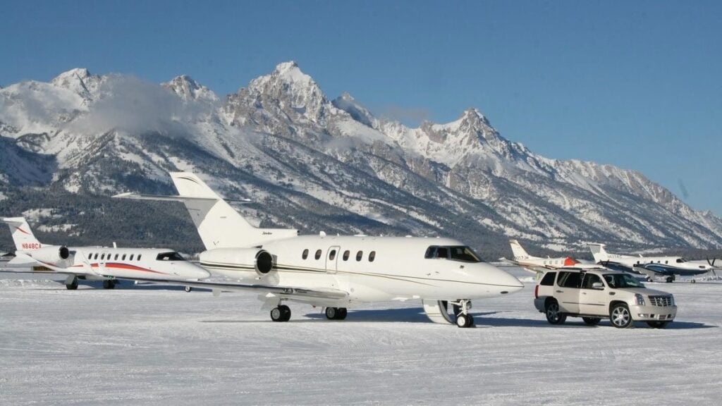 Private jets and SUV in snowy mountain airport