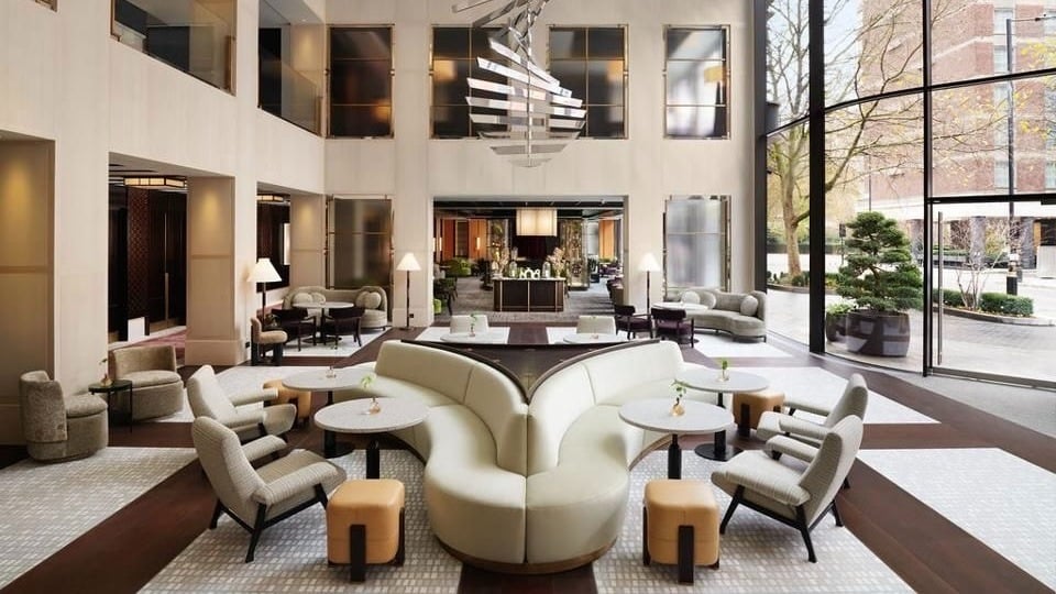 Modern hotel lobby with stylish furniture and large windows.