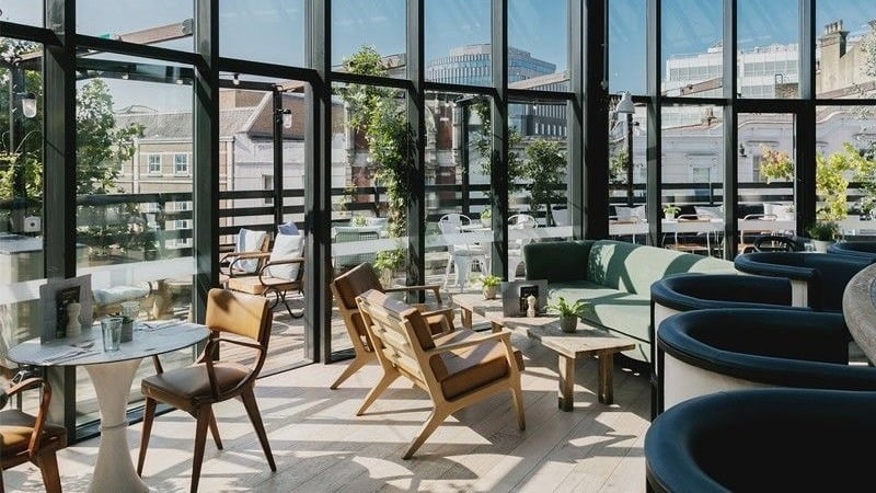 Modern rooftop lounge with city view and seating.