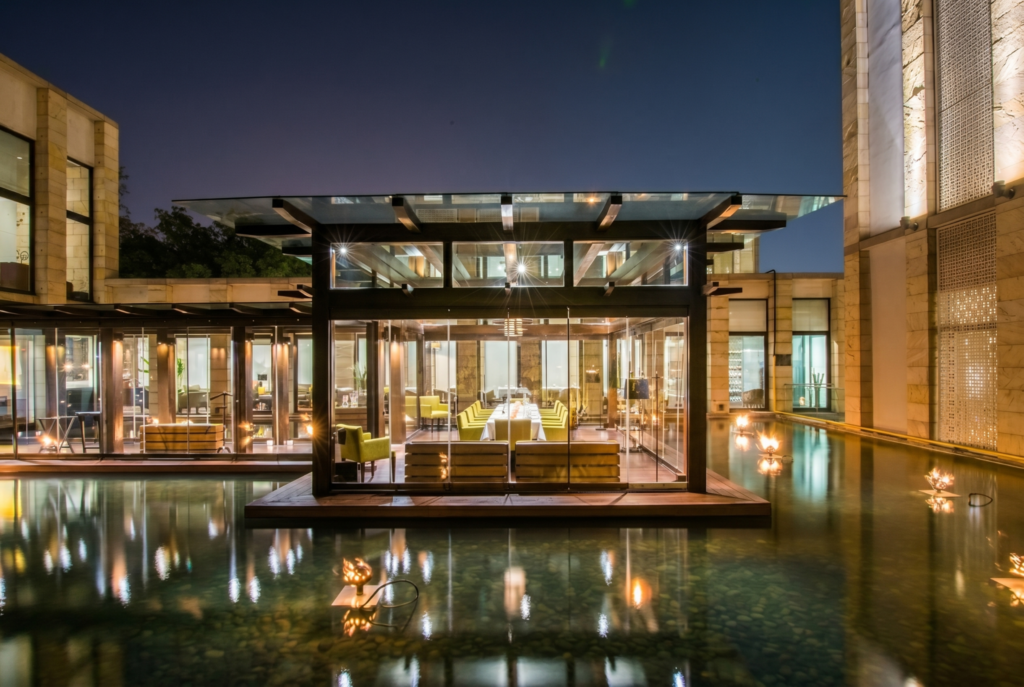 Modern glass pavilion over reflecting pool at night