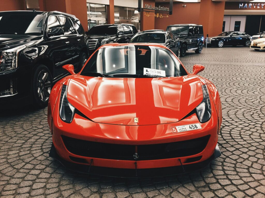 Red sports car on luxury showroom floor.