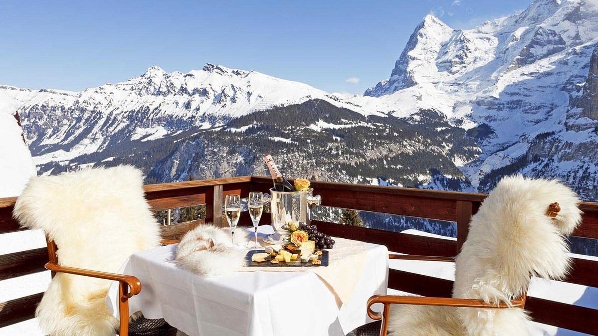 Winter mountain view with dining setup on balcony.