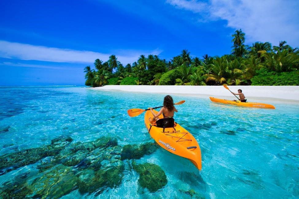 Two people kayaking in clear tropical waters.