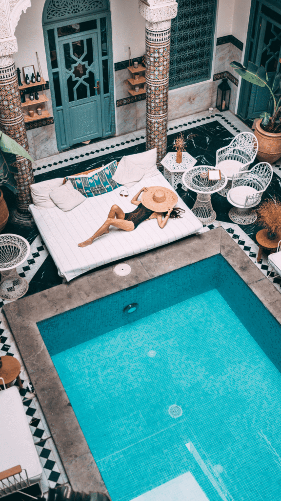 Relaxing by a pool in a Moroccan courtyard.