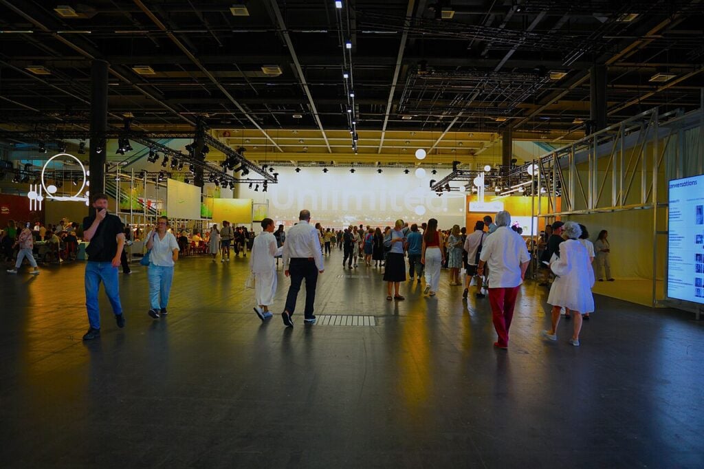 People walking in a large exhibition hall.
